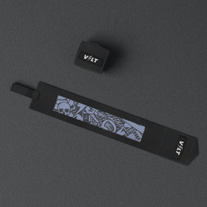 VOLT elastic wrist wraps, BlackEdition (grey print), one wrap laid out flat and one rolled, from above, on a rubber floor #BlackEdition
