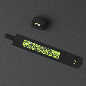 VOLT elastic wrist wraps, Original (lime print), one wrap laid out flat and one rolled, from above, on a rubber floor #Original