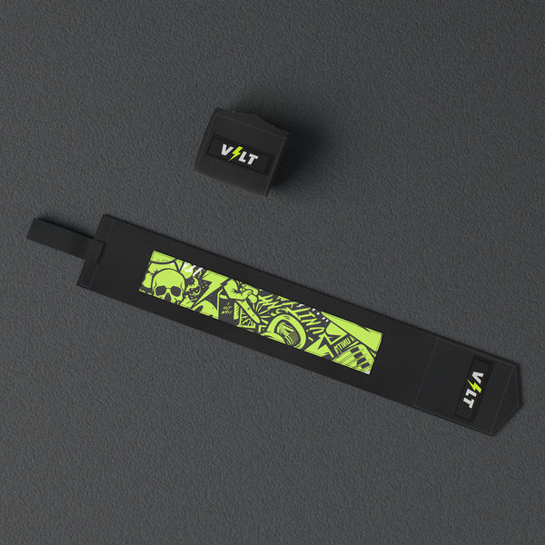 VOLT elastic wrist wraps, Original (lime print), one wrap laid out flat and one rolled, from above, on a rubber floor #Original