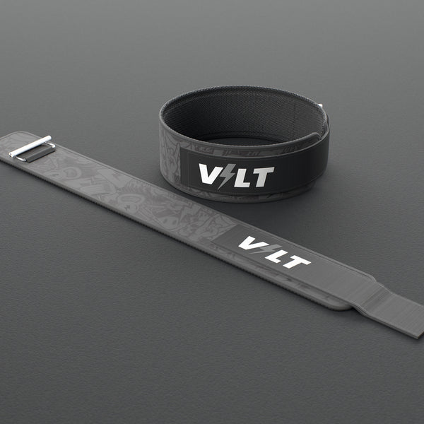 VOLT IronBelt 4" weightlifting belt, BlackEdition (grey print), one fastened and one laid flat, on a rubber floor #IronBeltBlackEdition