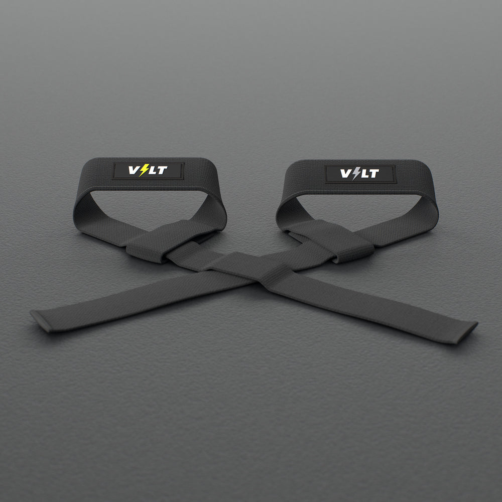 VOLT lifting straps, one Original (lime bolt) and one BlackEdition (grey bolt), on a grey rubber gym floor